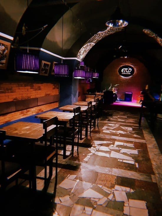 Rustic industrial bar in ETUD BAKU featuring a stage, perfect for networking or cocktail events.