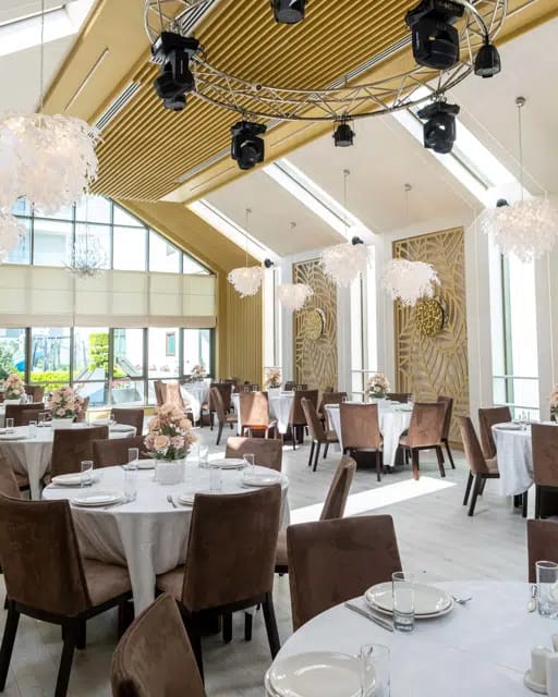 Elegant banquet hall at Badam d'Art Hotel with feather lighting for upscale social events.