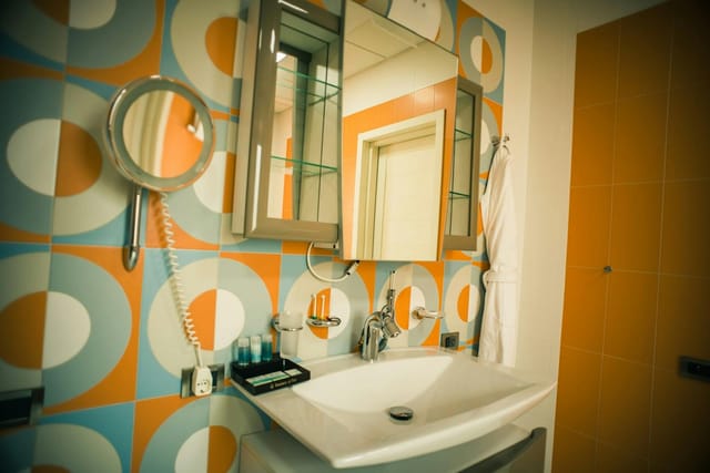 Mid-century tile bathroom at Badam d'Art Hotel, ideal for corporate event room blocks.
