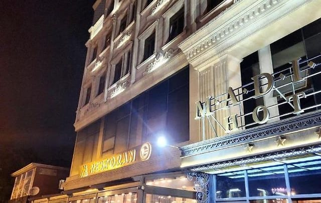 Boutique Adisson Hotel exterior at night: ideal venue for executive retreats and networking events.