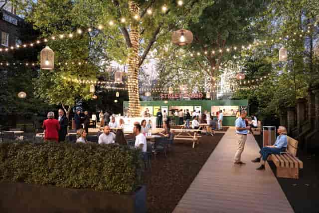 Outdoor networking party at Sunken Garden Bloomsbury with string lights and picnic seating.