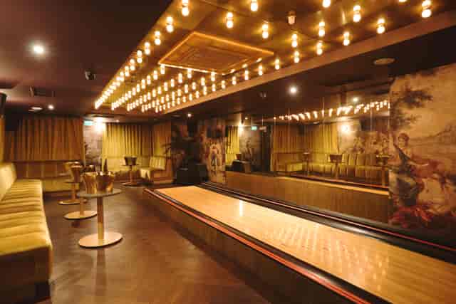 VIP bowling lounge with marquee lighting for corporate team building and networking events.