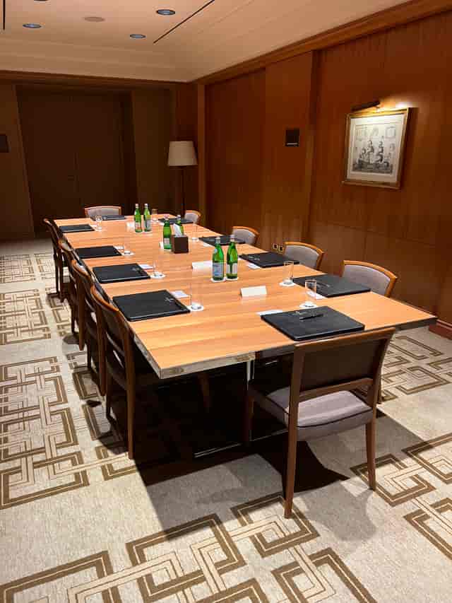 Four Seasons Milano boardroom setup for executive meetings with wood-paneled walls.