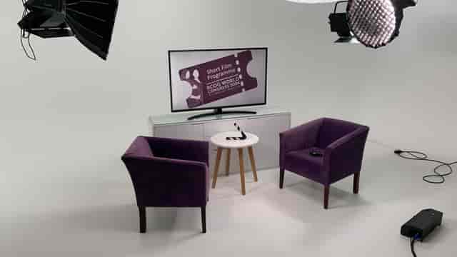 Event setup in Digital Studio with purple chairs and a TV screen for hybrid meetings.