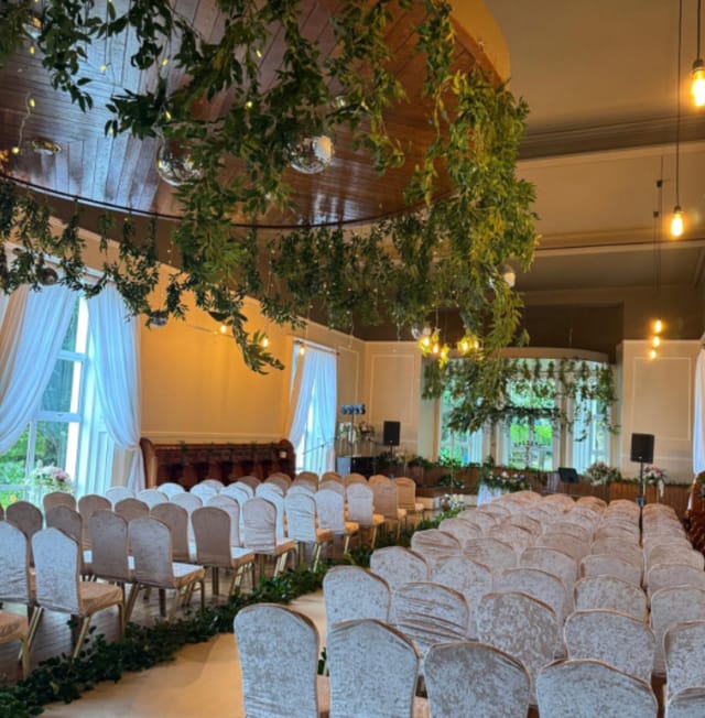 Orlagh House wedding ceremony with suspended greenery installation and elegant venue draping.