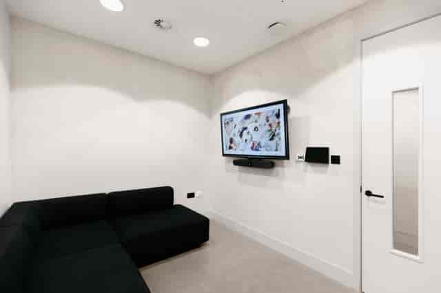 Minimalist huddle room with AV tech for corporate meetings and team collaboration.