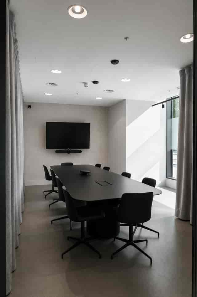 Modern minimalist boardroom with integrated AV technology for corporate meetings and conferences.