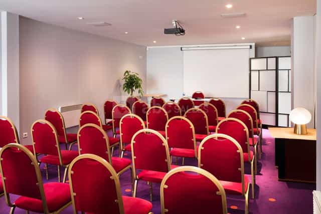Theater-style Lafayette meeting room with red chairs, ideal for corporate events and conferences.