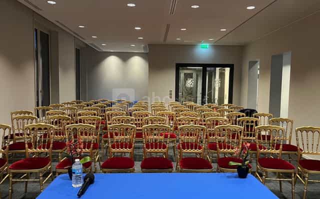 Theater-style seminar meeting room with red velvet chairs for professional event rental.