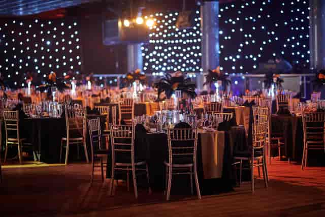 Redcoats at a black-tie gala, elegant starcloth backdrop, event styling and corporate dinner.