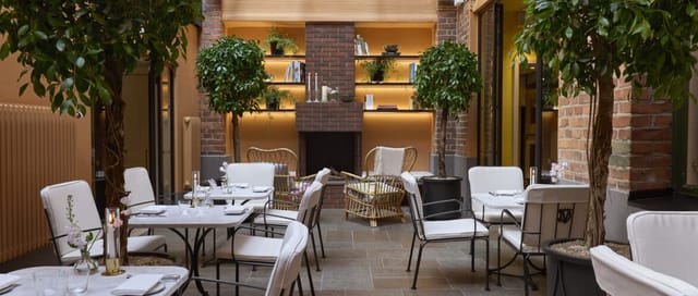 Upscale Garden breakout room at Hotel Villa Dagmar with brick fireplace for corporate events.