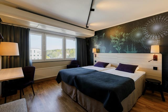 Modern twin hotel room at Scandic Järva Krog with workspace for corporate events and business travel.