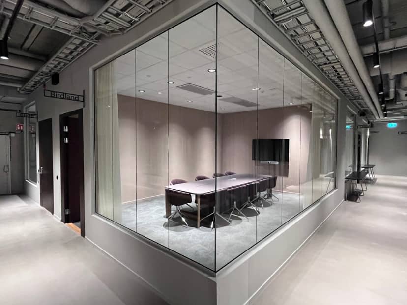 Modern glass boardroom for executive meetings and corporate breakout sessions.