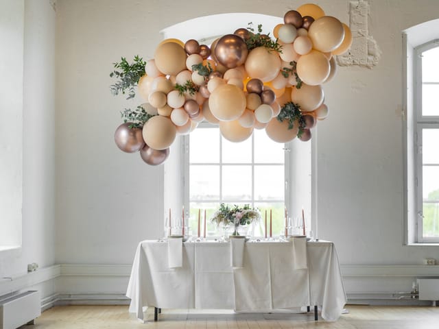 Organic balloon installation over head table for minimalist wedding or event decor.