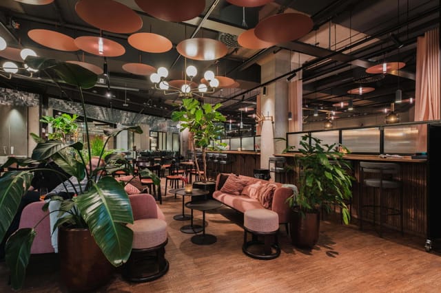 Biophilic cafeteria breakout space with plush lounge seating for corporate networking and events.