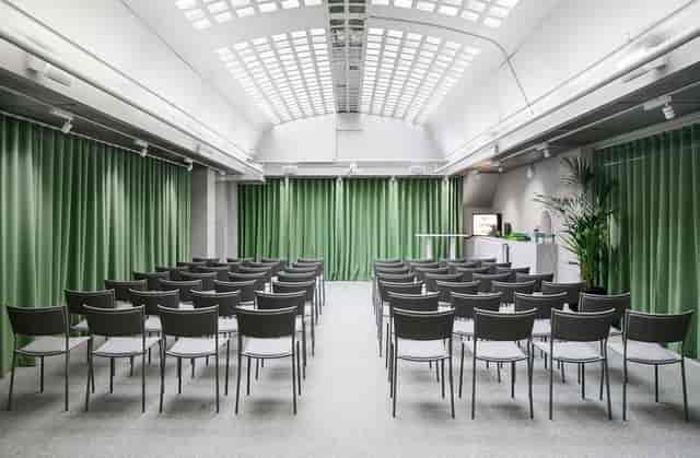 Modern theater-style conference room with skylight for corporate meetings and business events.