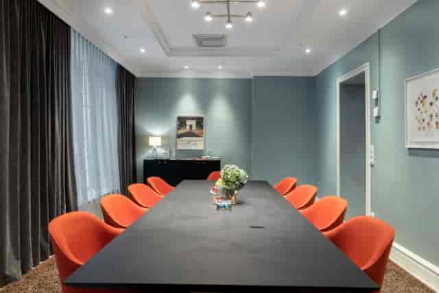 Boardroom at Hotel Stureplan with orange chairs for strategic meetings and client presentations.