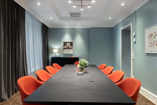 Boardroom at Hotel Stureplan with orange chairs for strategic meetings and client presentations.