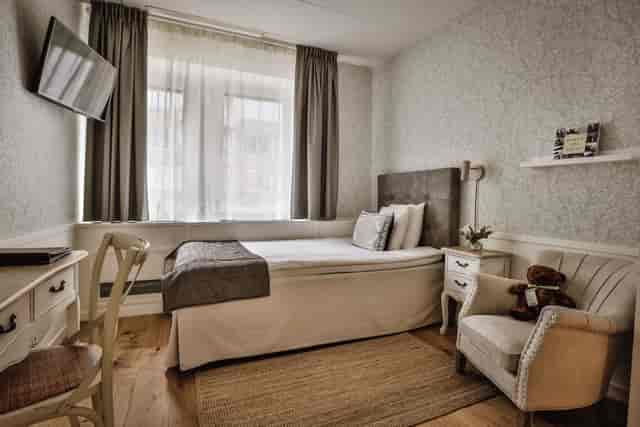 Single-occupancy hotel room with workstation for conference business travel.