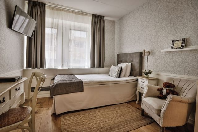 Single-occupancy hotel room with workstation for conference business travel.