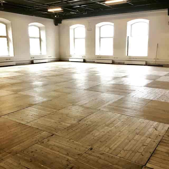 Glasverandan banquet hall with hardwood floors, ideal for event space and creative workshop venue.