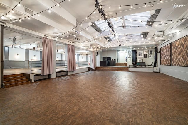 Industrial-chic event venue with bistro lighting, perfect for weddings and corporate receptions.