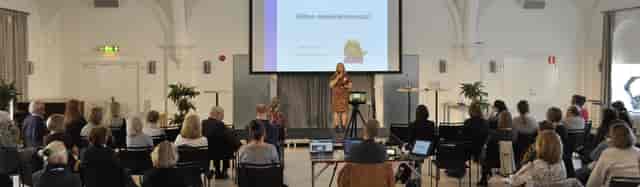 Presenter at Finlandsinstitutet Main Hall: hybrid event, professional conference setup.