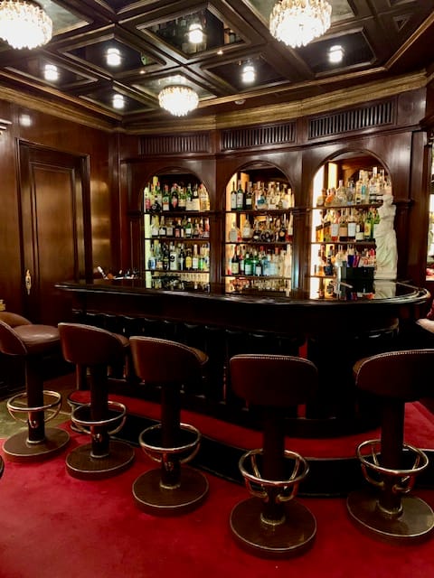 Palm Court hotel bar with wood paneling for VIP receptions and executive networking events.