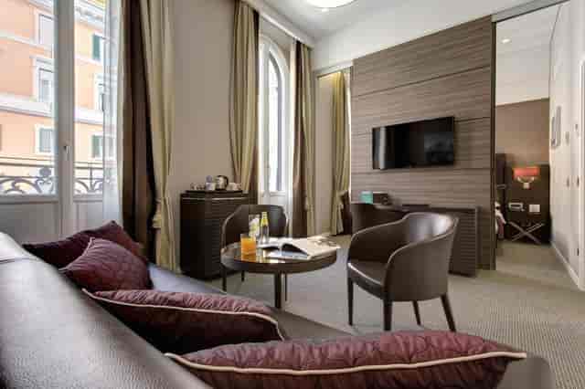 Junior suite at Hotel Artemide with meeting area for luxury business travel and corporate events.