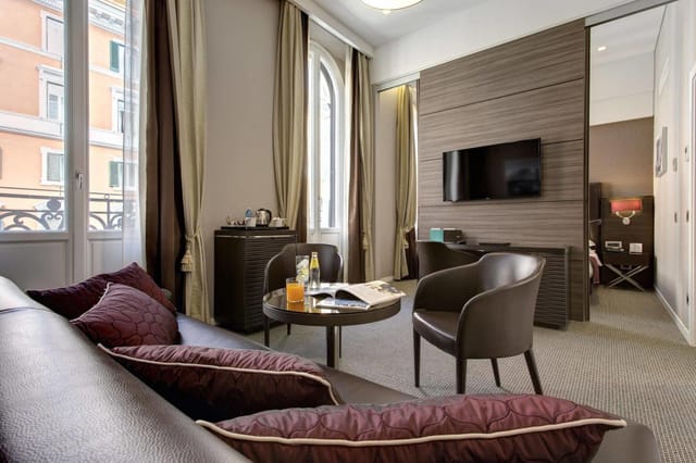 Junior suite at Hotel Artemide with meeting area for luxury business travel and corporate events.