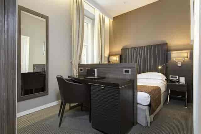 Hotel Artemide single suite with dedicated workspace for business conference travel.