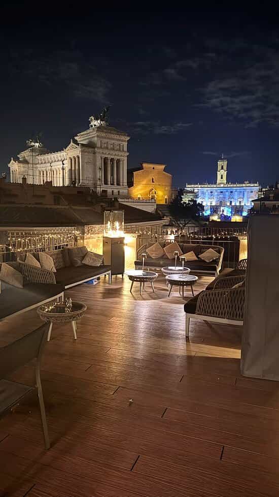 VIP cocktail reception at Rome rooftop bar with ambient lighting and plush lounge seating.