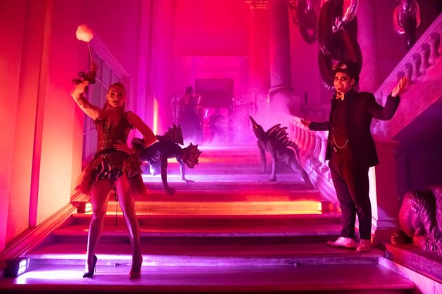 Immersive lounge activation with dramatic lighting and performers for experiential event marketing.