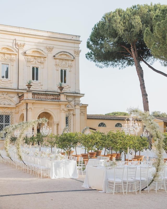 Luxury outdoor event at Villa Aurelia with classical architecture and manicured garden.