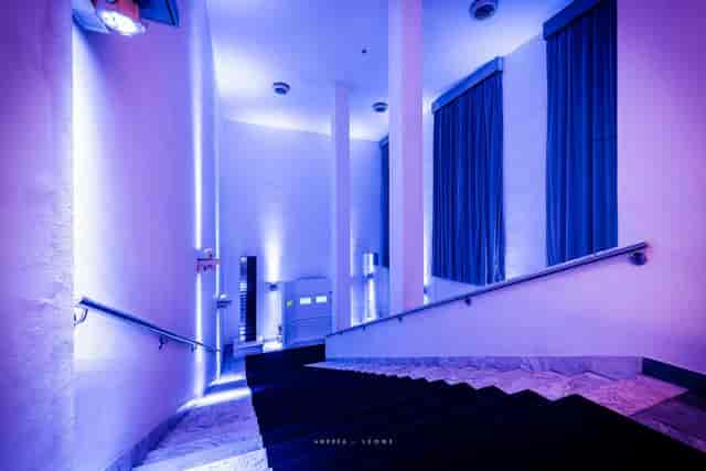 Minimalist gala event space at Spazio Novecento with dramatic architectural lighting.