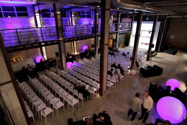 Officine Farneto industrial venue with purple LED lighting for corporate presentations and keynotes.
