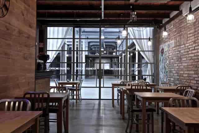 Industrial-chic Officine Farneto venue with warehouse atrium for corporate events and networking.