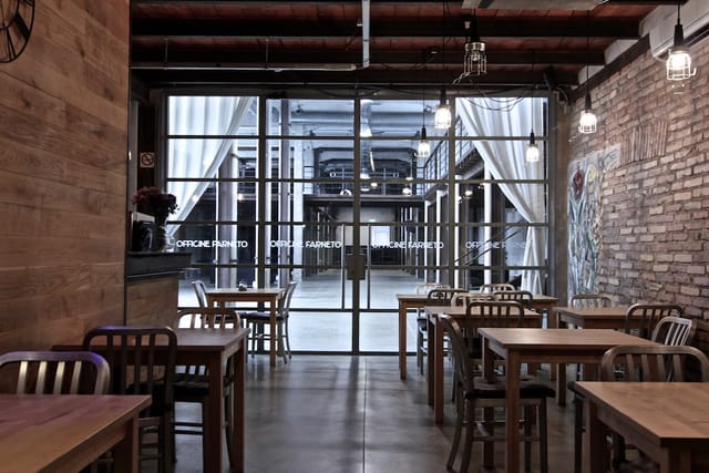 Industrial-chic Officine Farneto venue with warehouse atrium for corporate events and networking.