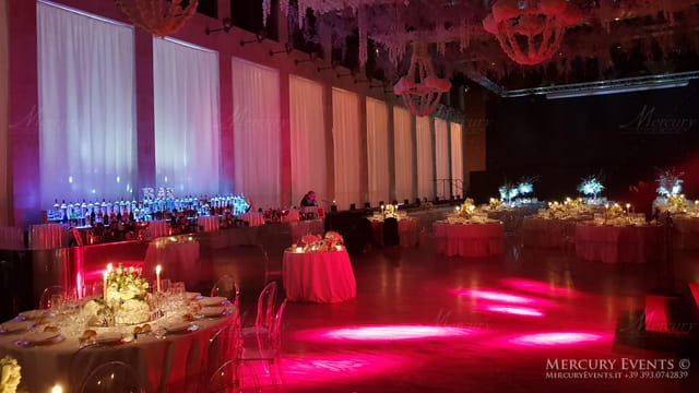 Modern gala event setup in Salone delle Fontane with ghost chairs and dramatic mood lighting.