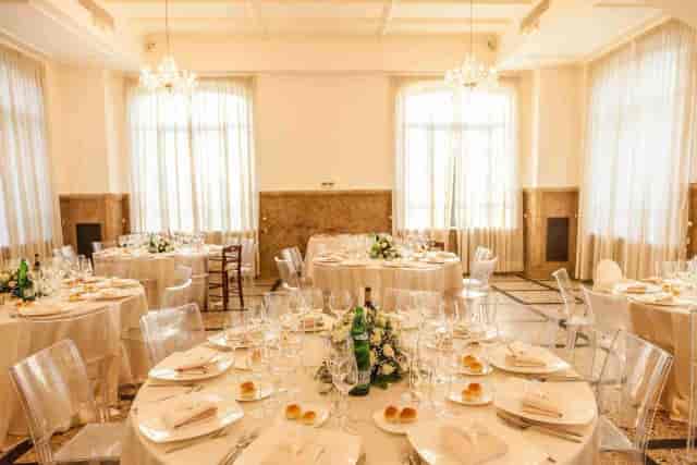 Nuova Villa dei Cesari gala dinner with ghost chairs and floral centerpieces for event venue.
