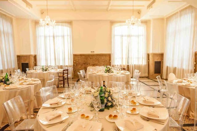 Nuova Villa dei Cesari gala dinner with ghost chairs and floral centerpieces for event venue.