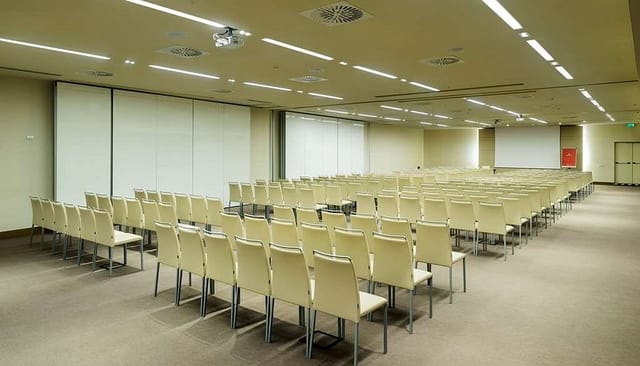 Theater-style conference room in Rome hotel with audiovisual setup for corporate events.