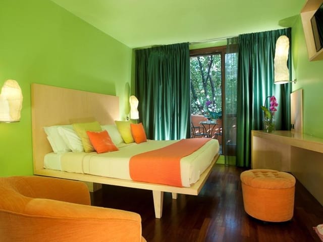 Vibrant modern hotel suite with bold lime and orange decor for boutique events and conferences.