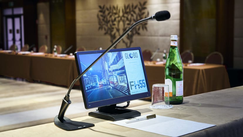 Cesarini Room boardroom setup with microphone and monitor for business meetings and conferences.