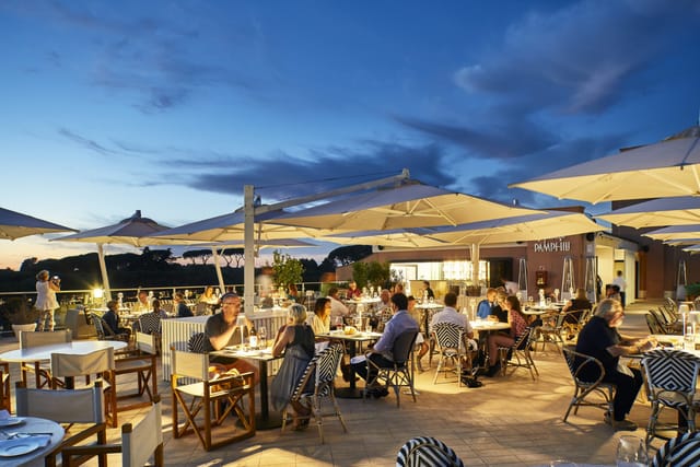 Outdoor networking reception at Hotel Villa Pamphili Roma with modular seating and elegant lighting.