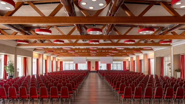Theater-style Fiera Roma conference center with timber beams for corporate events and keynotes.