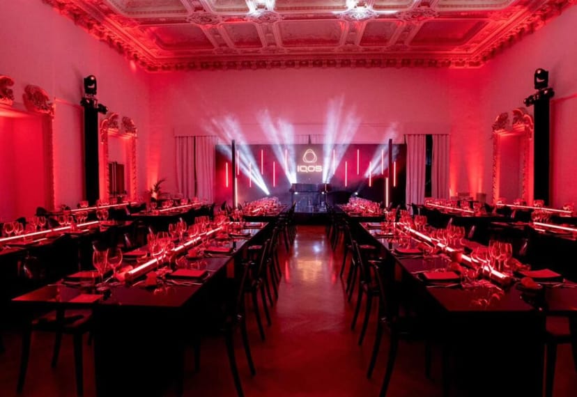 Red-lit gala dinner at Spazio Field event space for corporate networking.
