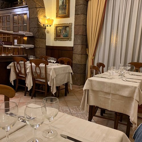 Rooftop restaurant at Suite Ludovisi with rustic dining tables for cozy event venue hire.