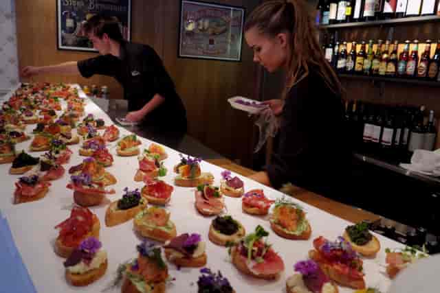 Catering staff plating artisanal crostini for a professional networking reception at Hotell Zinkensdamm.