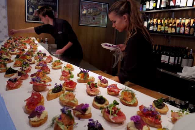 Catering staff plating artisanal crostini for a professional networking reception at Hotell Zinkensdamm.